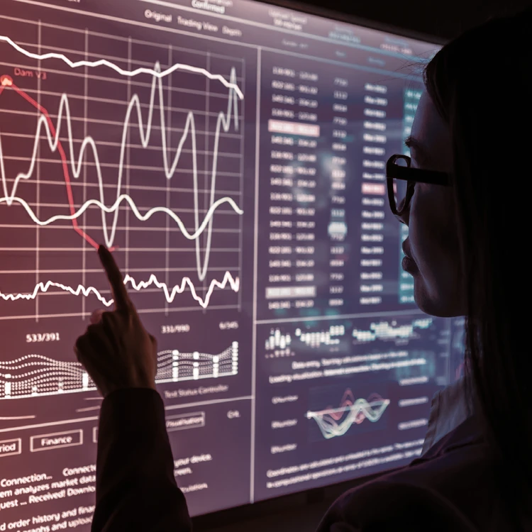 A close-up of a digital screen featuring complex financial data, statistical tables, and evolving stock charts for real-time market monitoring.